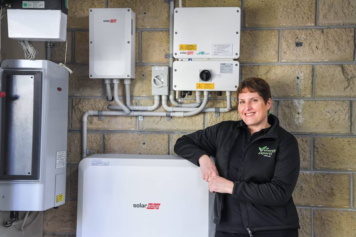 A picture of Caro, director of The Energy Experts, with a Solar Edge solar battery and inverter